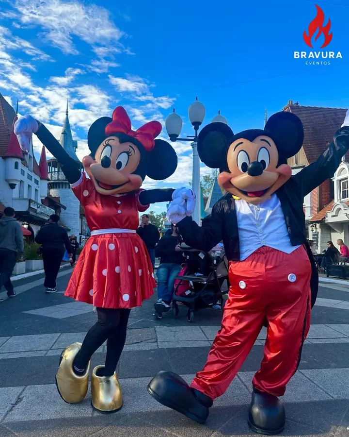 Mickey y Minnie saltando en una calle de un parque